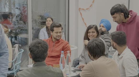 Junge Menschen sitzen zusammen und unterhalten sich.